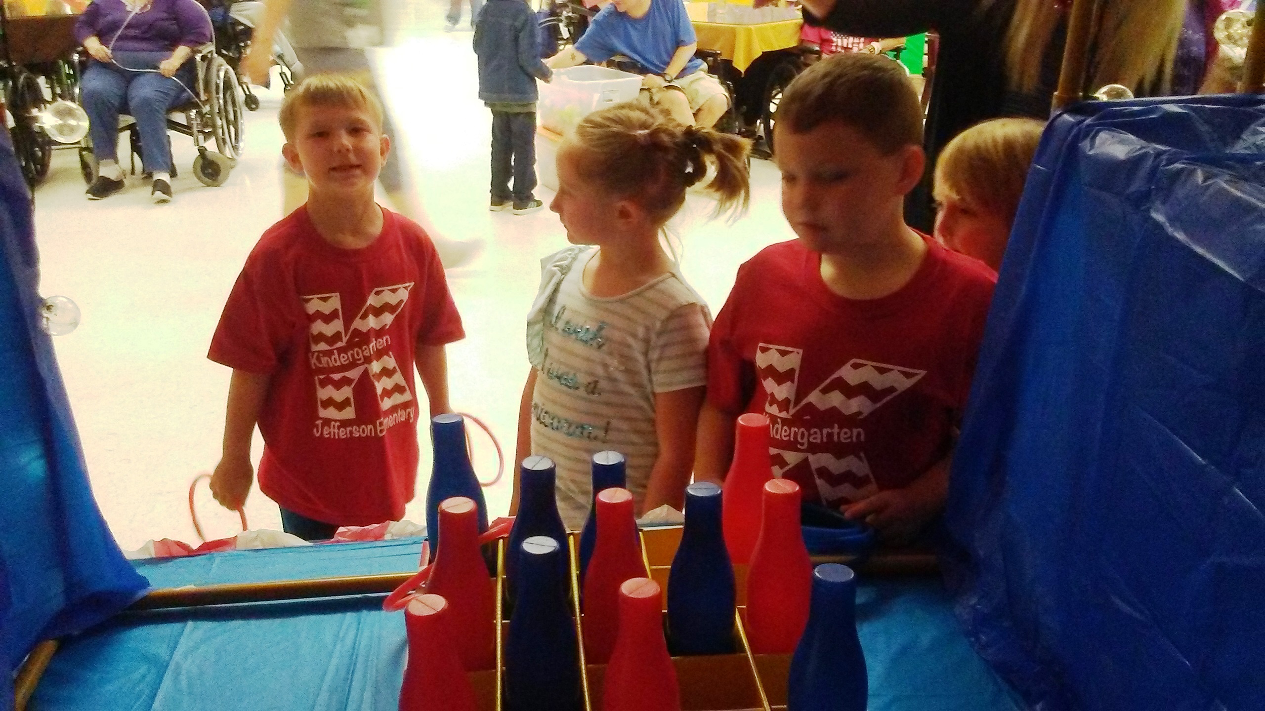 Kindergarten students playing at the ring toss in the carnival